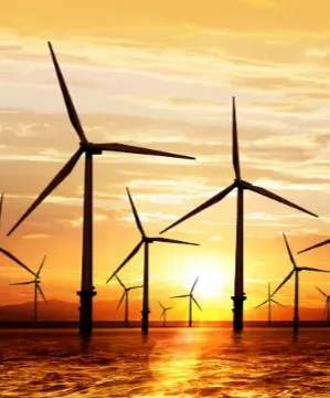 wind turbines in the ocean with a sunset background