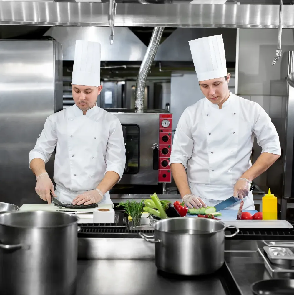 2 chefs in a kitchen preparing food 