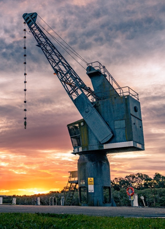 image of a large crane with a sunset background