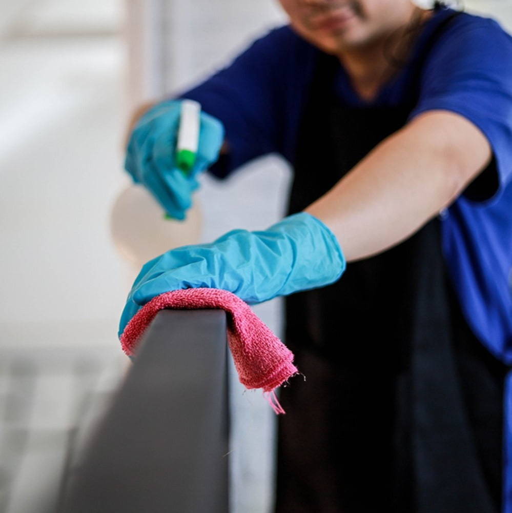 Person using cleaning products, wearing blue gloves