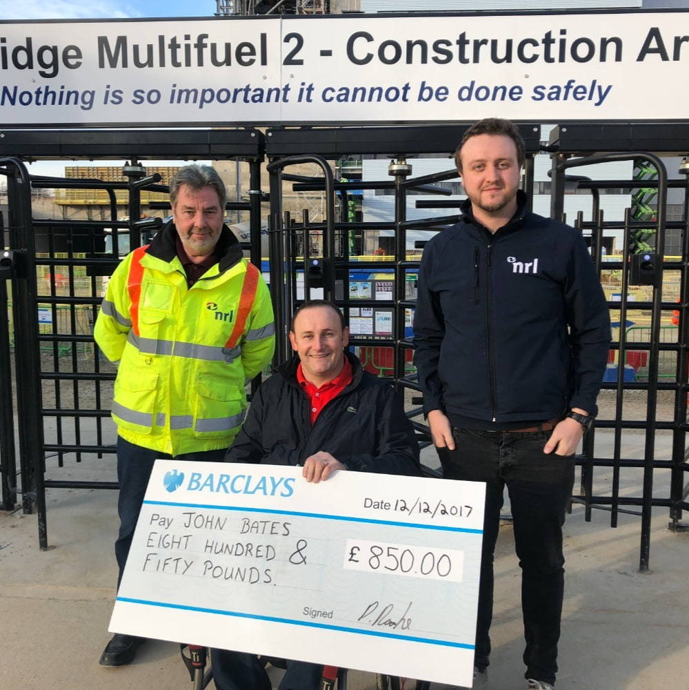 3 men holding a large cheque for £850 