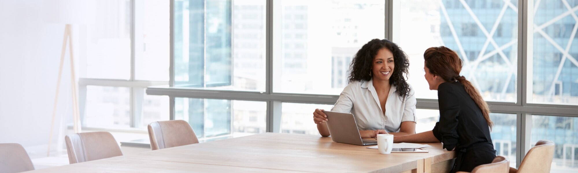woman talking to woman in office environment