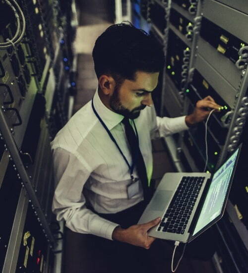 Man reviewing server performance on laptop