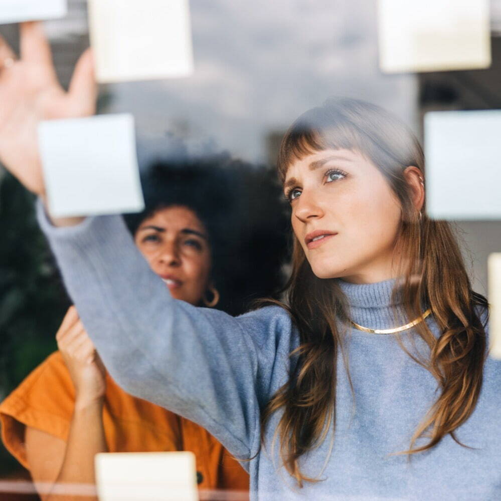 woman looking at a board with a colleague