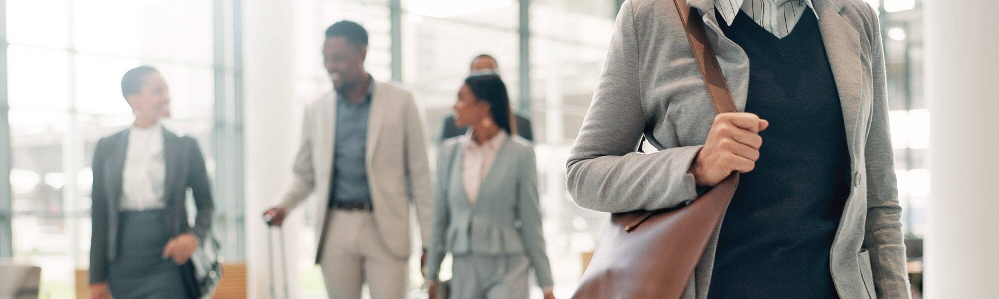 A group of business people walking with bags and suitcases, travelling.
