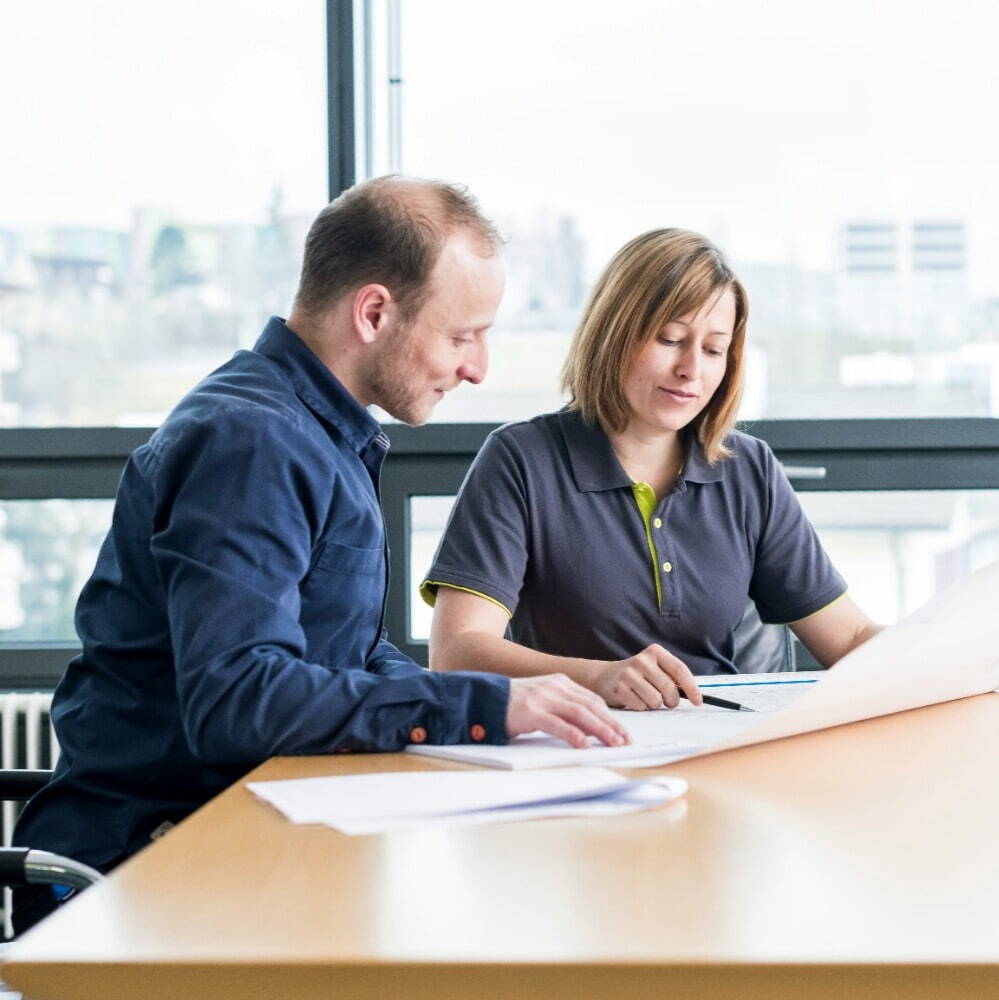 man and woman going through drawings at desk