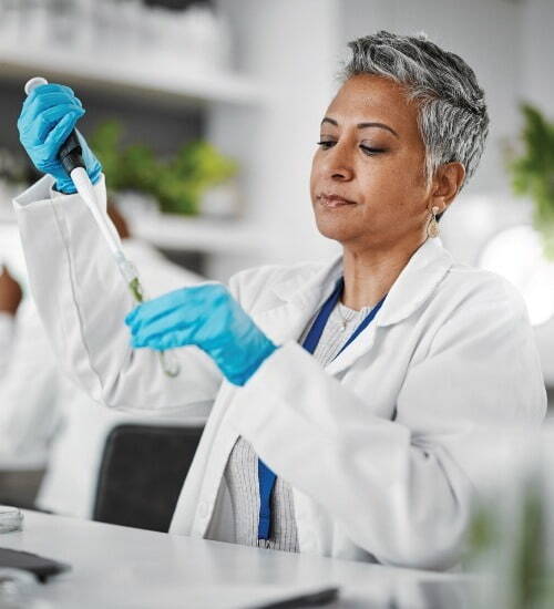 woman putting liquid into test tube